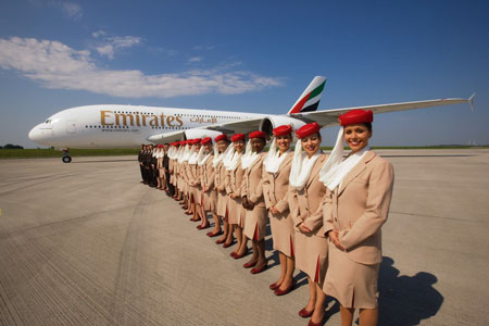 Cabin Crew von Emirates posiert vor Flugzeug