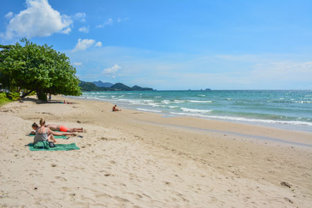 Badegäste Sonnenbaden am White Sand Beach auf der Insel Koh Chang obwohl es im Oktober noch oft in Thailand regnet