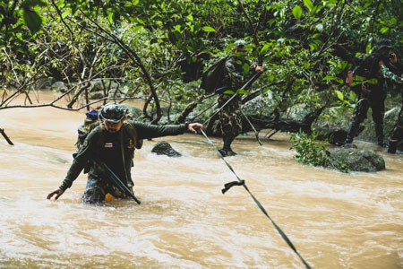 Park Ranger überquert Fluss im Dschungel des Pang Sida 