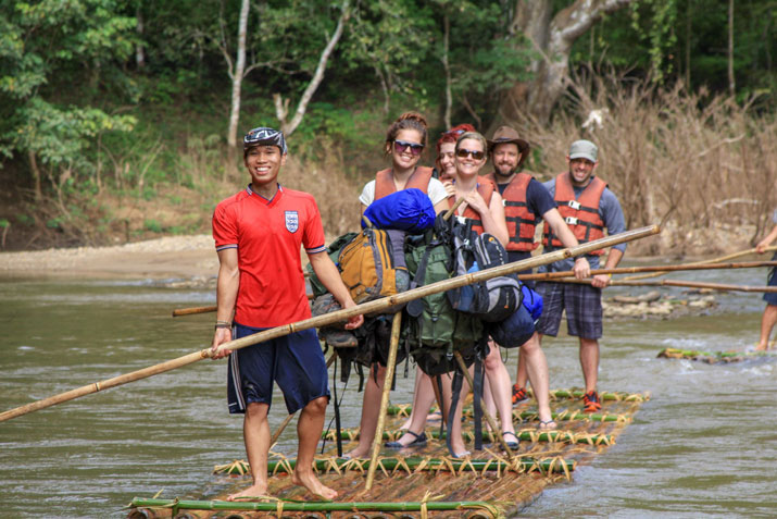 Touristen reisen mit einem Bambusfloß zu den Bergdörfern in Chiang Mai.