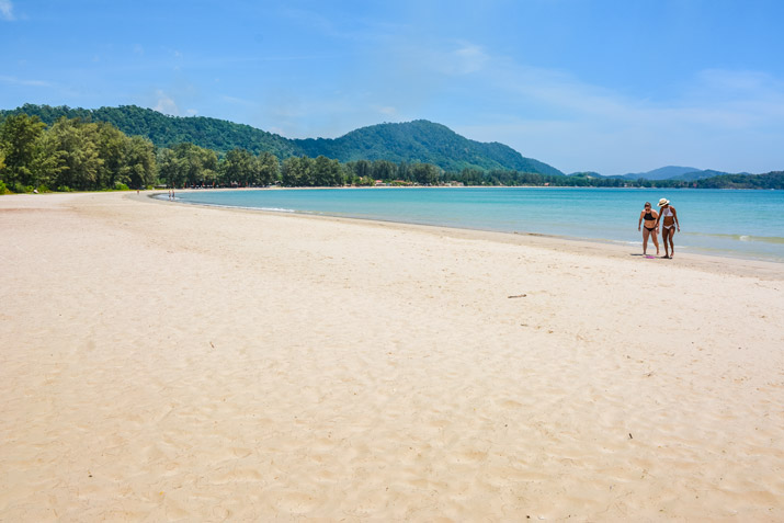 Zwei Touristinnen auf ihrem Inselhopping in der Andamanensee unternehmen einen Strandspaziergang auf der Insel Koh Lanta am Klong Dao Beach.