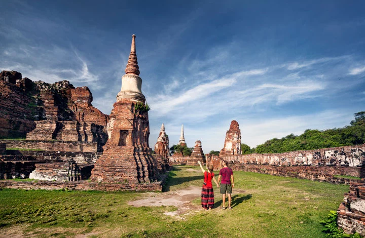 Touristen besuchen auf ihrer Thailand Rundreise den Tempel Wat Mahathat in Ayutthaya.
