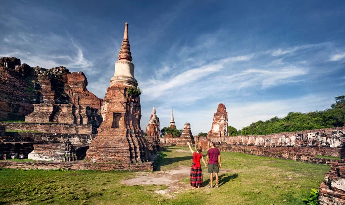 Touristen besichtigen auf ihrer Thailand Reise die Tempel von Ayutthaya.