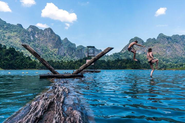 Touristen springen auf ihrer Tour zum Baden in den Chiao Lan See im Khao Sok Nationalpark.
