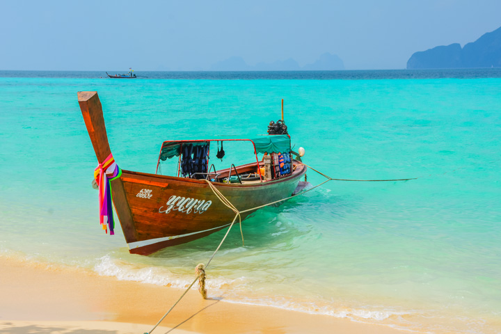 Longtailboot am Strand des Sunrise Beach auf Koh Kradan in Thailand.