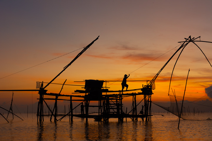 Fischer am traditionellen Yor Yak Netz bei Sonnenaufgang im Thale Noi See in Phattalung.